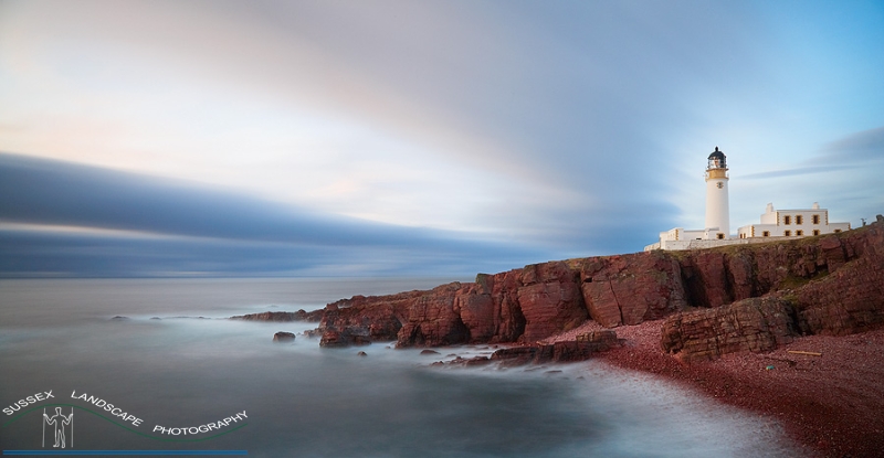 slides/Rubh Re Lighthouse.jpg rub re lighthouse,scotland,coast,ocean,water,misty,rocks,surf,crashing,red rock,clouds,sunset, motion, movement,panoramic Rubh Re Lighthouse